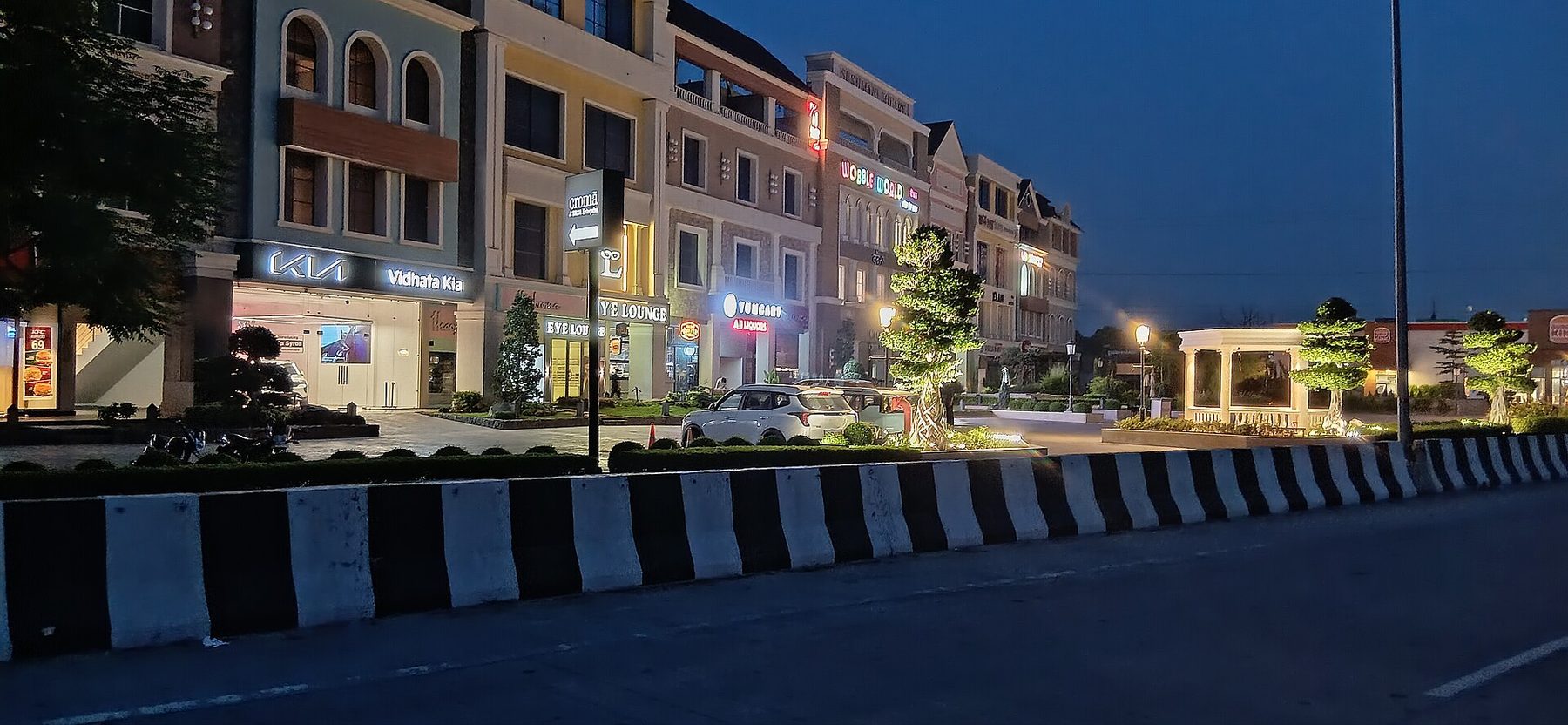 Lit shopfronts along Sukhmani Square, Ludhiana, at night
